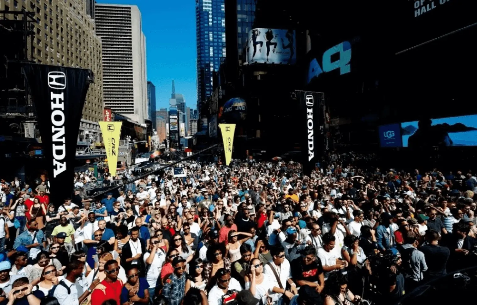 A large crowd gathered in a city street during the day.