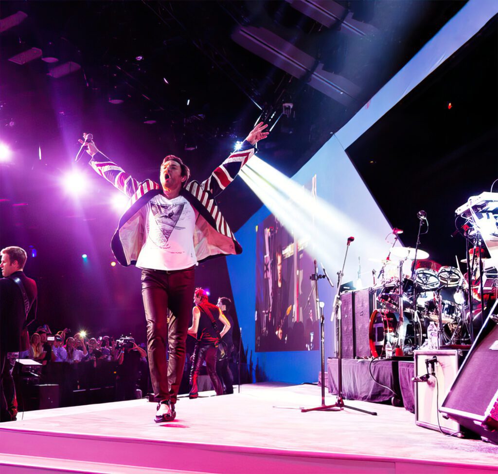 Energetic performer on stage under vibrant purple lighting at a live concert.