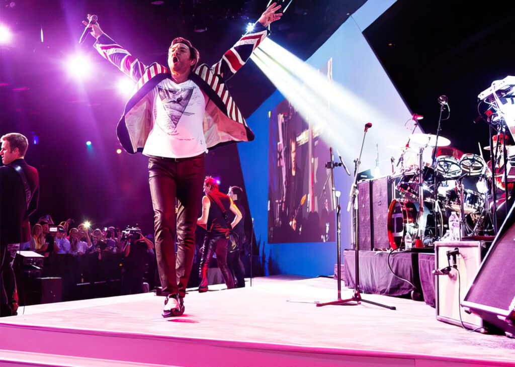 Energetic performer leaps on stage during a vibrant concert under bright lights.